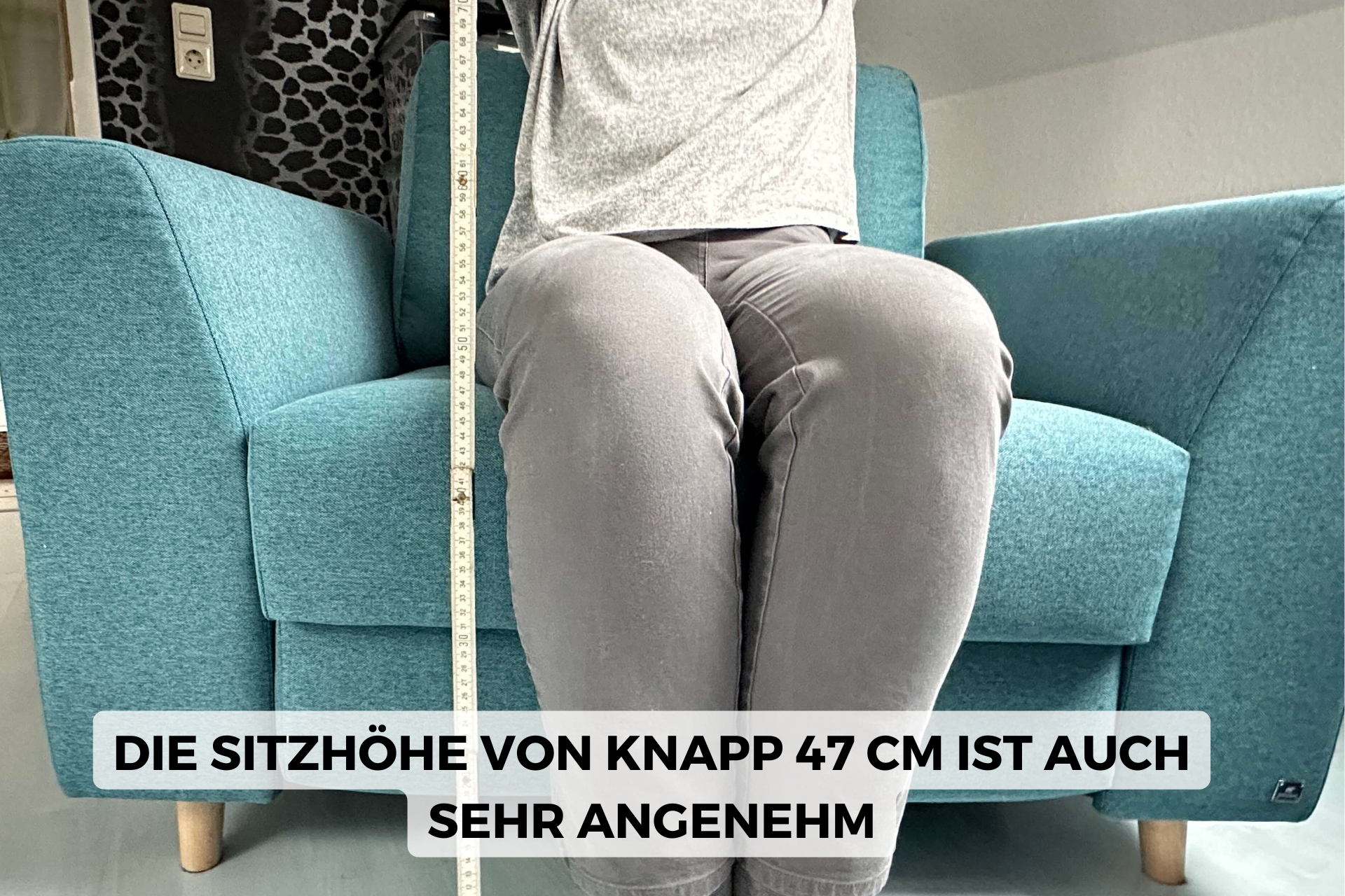 Testperson sitzt auf Schlafsessel mit Meterstab